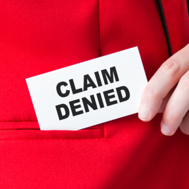 Businessman putting a card with text Claim Denied in the pocket