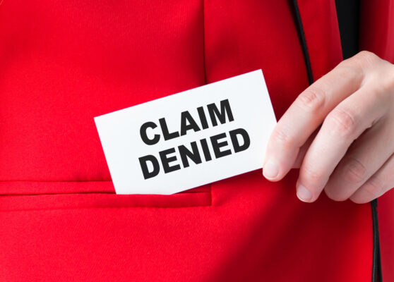 Businessman putting a card with text Claim Denied in the pocket